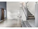 Bright entryway features wood flooring, a staircase with white railings, and a view into the kitchen at 2691 E 132Nd Ave, Thornton, CO 80241