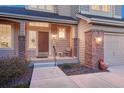 Charming front porch with brick accents, offering a welcoming entrance to this well-maintained home at 7454 Snow Lily Pl, Castle Pines, CO 80108