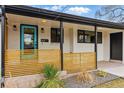 Welcoming front porch with a vibrant blue door, stylish wood slat railing, and modern outdoor lighting at 1920 S Niagara St, Denver, CO 80224