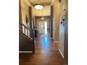 Inviting foyer with hardwood floors, decorative lighting, and a staircase leading to the upper level at 17046 Wellington Dr, Parker, CO 80134