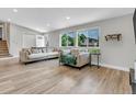 Bright living room with new floors, and comfortable seating, and a view of the front yard at 6441 W 73Rd Pl, Arvada, CO 80003