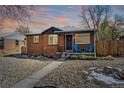 Charming brick home featuring a well-maintained front yard with colorful sky at dusk at 3258 Niagara St, Denver, CO 80207