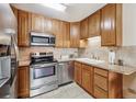Bright kitchen with stainless steel appliances, tile backsplash, and light wood cabinets at 715 S Alton Way # 5D, Denver, CO 80247