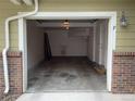 Empty attached one car garage with access door, concrete floor, and brick siding at 11947 Riverstone Cir # 7F, Henderson, CO 80640