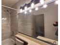 Updated bathroom features a shower over tub and modern vanity lighting fixture at 1818 S Quebec Way # 5-7, Denver, CO 80231