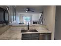 Open kitchen featuring stone countertops, modern faucet, view of living room and staircase at 1818 S Quebec Way # 5-7, Denver, CO 80231
