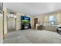 Inviting living room with neutral walls, gray carpet, and a cozy fireplace at 6651 S Dudley Ct, Littleton, CO 80123