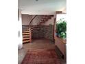 Elegant foyer featuring a unique curved staircase, stone accent wall, and beautiful tile flooring at 4618 Se Summit Trl, Evergreen, CO 80439