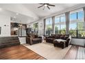 Bright living room featuring large windows, hardwood floors, and an open layout leading to the kitchen at 10731 E 151St Pl, Brighton, CO 80602