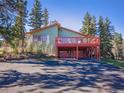 View of the exterior of the home showcasing a large balcony and lower level parking at 8473 Gray Fox Dr, Evergreen, CO 80439