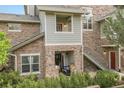Charming townhome featuring a stone facade, private entrances, and lush green landscaping at 18761 E Water Dr # F, Aurora, CO 80013
