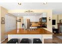 Kitchen featuring a wooden island, white cabinetry, and stainless steel appliances at 19716 Glendale Ln, Parker, CO 80134