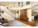 Open-concept living room featuring high ceilings, a staircase, and a decorative china cabinet at 19716 Glendale Ln, Parker, CO 80134