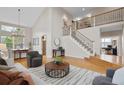 Bright living room with vaulted ceilings, hardwood floors, and a staircase with iron railing at 13804 Quail Ridge Dr, Broomfield, CO 80020