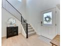 Inviting entryway featuring a staircase, light wood floors, and natural light at 15389 W 50Th Dr, Golden, CO 80403