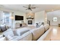 Cozy living room featuring a stone fireplace, ceiling fan, and hardwood floors at 15389 W 50Th Dr, Golden, CO 80403