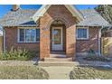 Brick facade with arched entryway, steps, and well-manicured landscaping at 4336 Thompson Ct, Denver, CO 80216