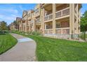 Street-level view of a row of townhouses, each featuring balconies, brick accents, and landscaped walkways at 10241 Bellwether Ln, Lone Tree, CO 80124