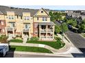 Tan colored townhouse showcasing a double balcony, brick accents, and well-maintained landscaping at 10241 Bellwether Ln, Lone Tree, CO 80124