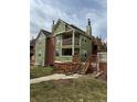 View of the green townhouse from the front with stairs leading to the front door, a clean landscape, and a pleasant sky at 3025 Broadway St # 17, Boulder, CO 80304