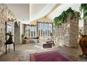 Elegant living room featuring stone accent walls, soaring ceilings and natural light at 108 Castle Pines N Dr, Castle Rock, CO 80108