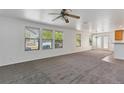 Spacious living room featuring neutral carpet, bright windows, and a ceiling fan at 5798 Biscay St, Denver, CO 80249