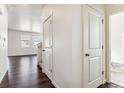 Hallway with hardwood floors, white trim, and doorways to other rooms in the house at 27460 E Cedar Pl, Aurora, CO 80018