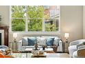 Living room featuring a sofa with blue pillows, two chairs, a large window, and an ornamental table setting at 5419 Uinta St, Denver, CO 80238