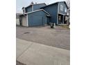 Exterior view of a townhouse showing the garage and parking area at 10008 Quivas St, Thornton, CO 80260