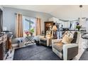 Comfortable living room with a large window, recliner seating, and open layout to the kitchen at 3762 S Halifax St, Aurora, CO 80013