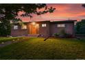 Charming brick home with lovely landscaping, wooden accents, and a well-manicured lawn at 6205 Pierce St, Arvada, CO 80003