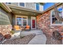 Inviting covered front porch with comfortable seating and stylish brick accents at 23593 E Eads Dr, Aurora, CO 80016
