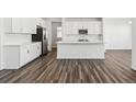 Modern white kitchen with stainless steel appliances, a center island, and sleek countertops at 16651 W 93Rd Ave, Arvada, CO 80007