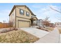 Inviting front exterior showcases a two-story home with a well-kept lawn, and long driveway on a sunny day at 19120 E Pacific Pl, Aurora, CO 80013