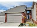 Inviting brick townhome with two car garage and well-manicured lawn offers curb appeal at 9403 Southern Hills Cir, Lone Tree, CO 80124