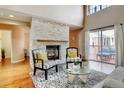 Sunlit living room boasts a stone fireplace, high ceilings, and access to a deck at 9403 Southern Hills Cir, Lone Tree, CO 80124