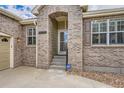 Inviting front entrance with brick archway, glass door and security system at 23808 E Bellewood Dr, Aurora, CO 80016