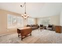 Bright living room featuring neutral carpet, elegant chandelier, and abundant natural light at 23808 E Bellewood Dr, Aurora, CO 80016