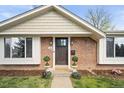 Inviting front entrance features brick facade, decorative plants, updated lighting and stylish front door at 1100 Pontiac St, Denver, CO 80220
