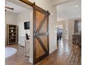 Living room featuring a decorative barn door and hardwood floors at 8505 S Tibet Ct, Aurora, CO 80016