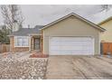 Home exterior features a two car garage with a beige and brick facade and well-maintained landscaping at 19558 E Purdue Pl, Aurora, CO 80013