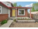 This property features a brick porch with a yellow door and a garden perfect for enjoying sunny afternoons at 6337 W 68Th Pl, Arvada, CO 80003