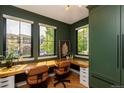 Bright and modern home office with custom built-ins, large windows, and stylish decor at 2899 Emporia Ct, Denver, CO 80238