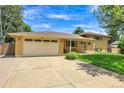 Charming brick home featuring a two-car garage, covered entryway, and well-manicured lawn at 960 S Arbutus St, Lakewood, CO 80228