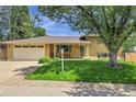 Charming brick home featuring a two-car garage, covered entryway, and well-manicured lawn at 960 S Arbutus St, Lakewood, CO 80228