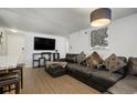 Living area boasts a large leather sectional sofa, media console, and stylish artwork for comfortable living at 1260 York St # 102, Denver, CO 80206