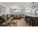Spacious living area showcasing a comfortable leather sectional sofa, bar cart, and bright shuttered windows at 1260 York St # 102, Denver, CO 80206