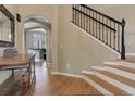 Inviting home foyer with hardwood floors, a staircase with a black iron railing, and arched doorways at 3070 Redhaven Way, Highlands Ranch, CO 80126