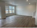 Living room features hardwood floors, recessed lighting, three large windows and white walls at 28615 E 6Th Pl, Watkins, CO 80137