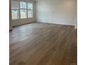 Spacious living room featuring hardwood floors and large windows for natural light at 28615 E 6Th Pl, Watkins, CO 80137
